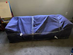 A large item covered with a moving blanket